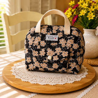 “Handmade floral quilted cotton lunch bag with front pocket and soft handles displayed on wooden table”