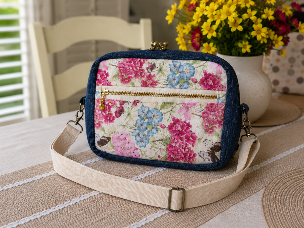 Handmade floral shoulder bag with front pocket and quilted fabric design.