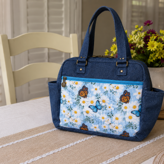 Handmade butterfly quilted shoulder bag with floral fabric, front zipper pocket, and double zipper top closure