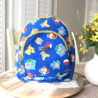 Handmade blue character-inspired mini backpack with quilted fabric, zipper compartments, and boutique-style design.