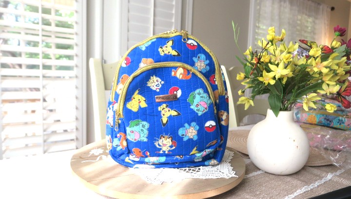 Handmade floral mini backpack featuring quilted fabric, boutique-style craftsmanship, and practical everyday storage.
