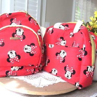 Handmade red matching backpack and shoulder bag set displayed together on a table.