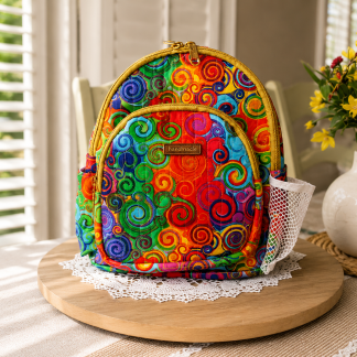 Handmade colorful swirl mini backpack with quilted fabric, zipper compartments, side pockets, and boutique-style design.
