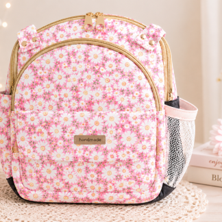 Handmade pink floral mini backpack with quilted fabric, boutique-style design, zipper compartments, and soft feminine aesthetic.