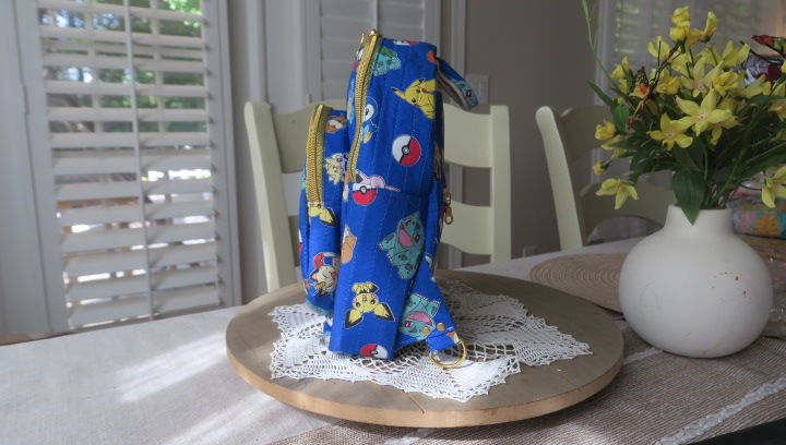 Handmade blue character-inspired mini backpack with quilted fabric, zipper compartments, and boutique-style design.