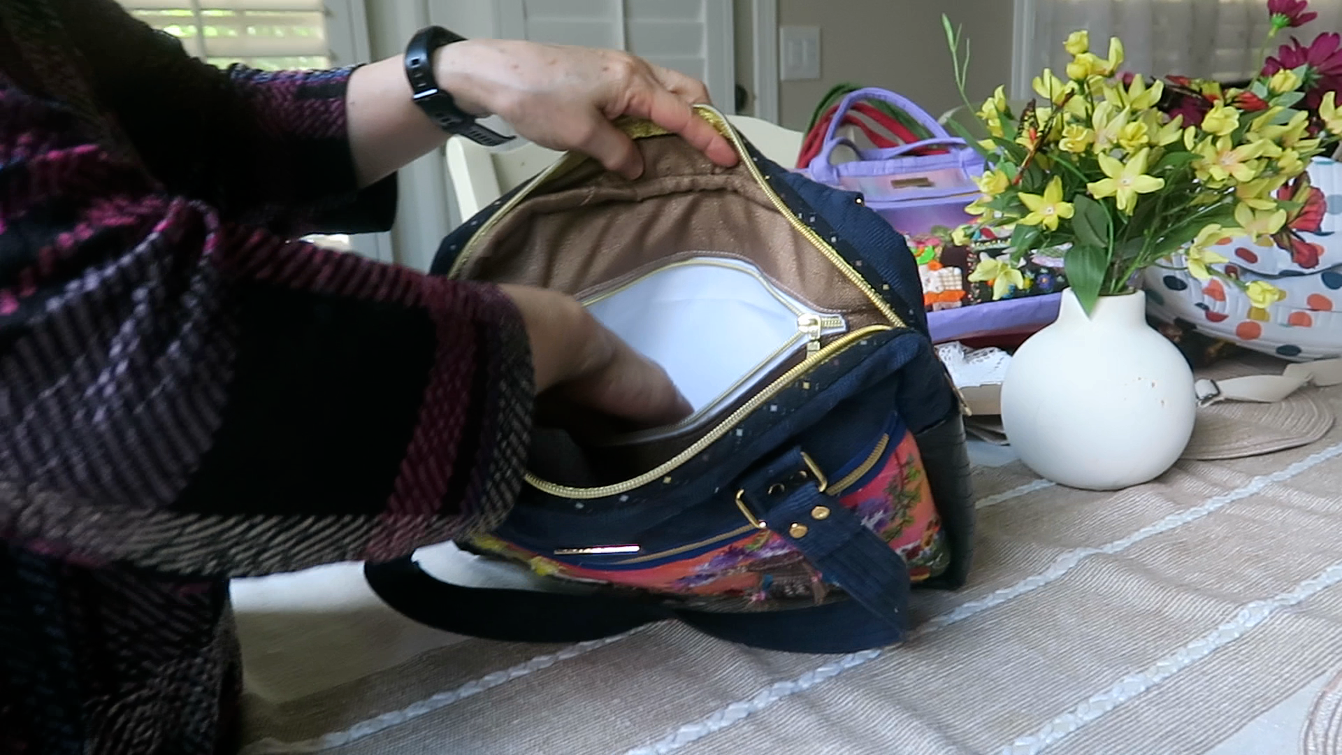 Interior view of handmade floral shoulder bag showing zippered storage pocket and spacious compartment for iPad and notebooks.