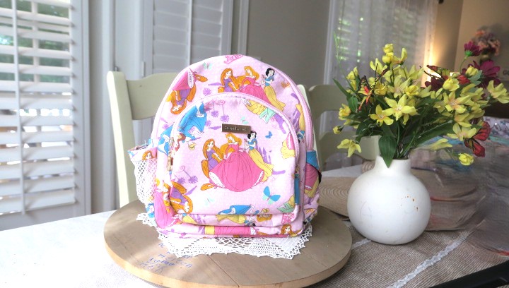 Handmade floral mini backpack featuring quilted fabric, boutique-style craftsmanship, and practical everyday storage.