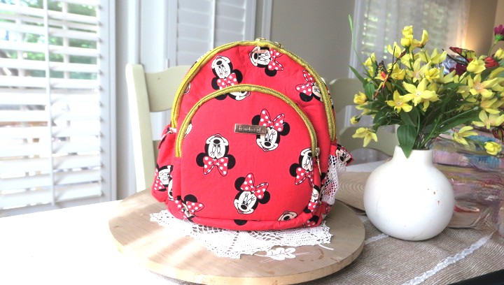Handmade floral mini backpack featuring quilted fabric, boutique-style craftsmanship, and practical everyday storage.
