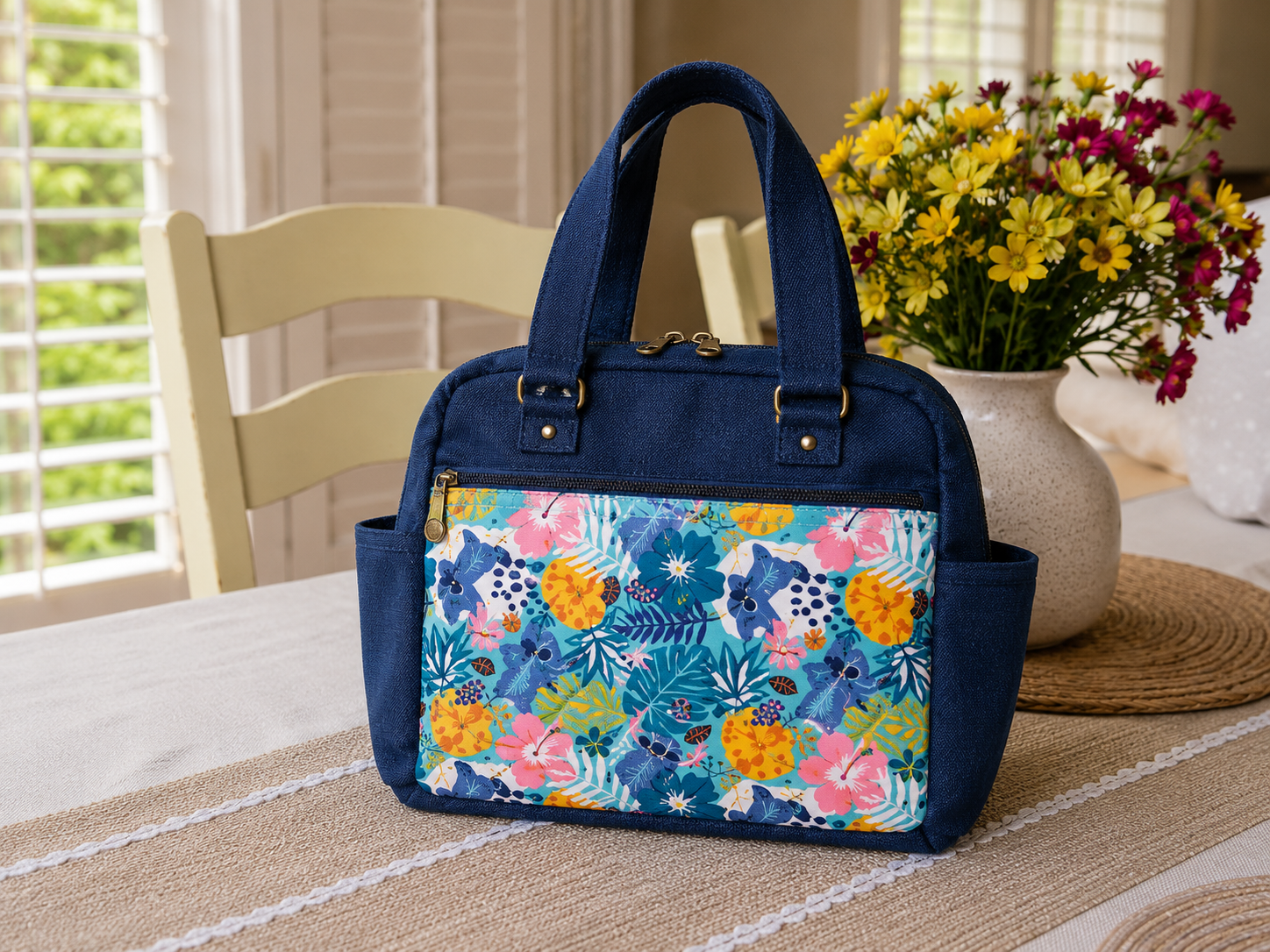 Handmade quilted shoulder bag with floral fabric, front zipper pocket, and double zipper top closure