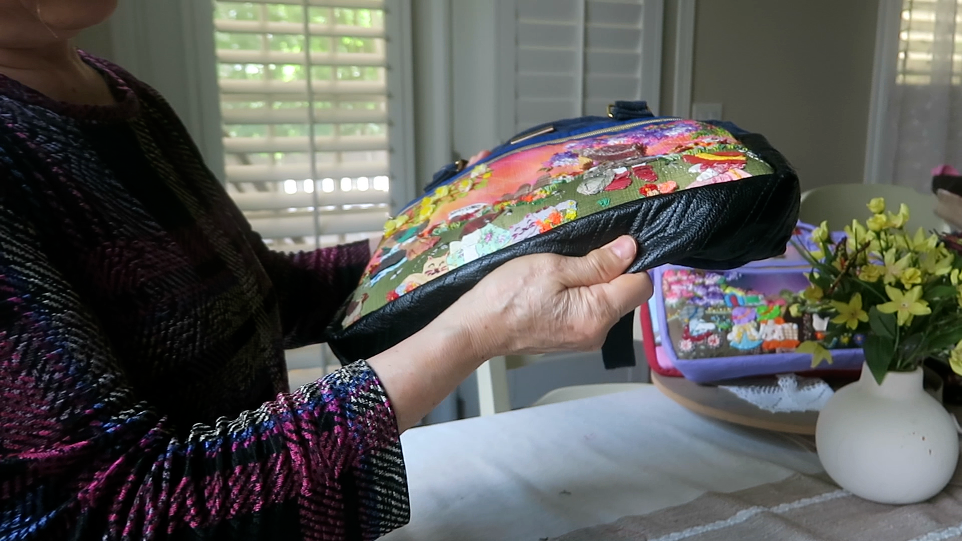 Handmade floral shoulder bag featuring soft waterproof leather on the bottom and sides for added durability and protection.