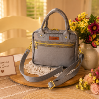 Handmade gray Shoulder Bag and Handbag Combo with adjustable shoulder strap and gold zipper displayed on a wooden tray with flowers in a warm home setting.