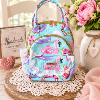 Handmade pink flamingo backpack with aqua quilted canvas, decorative white lace and gold-tone zippers.
