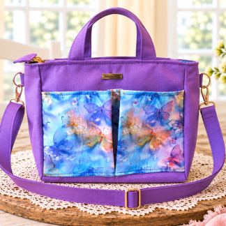 Handmade purple butterfly tote and shoulder bag with colorful blue floral front pockets.